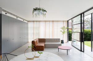 Modern interior living area with babylon light above a dining table