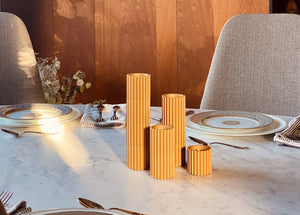 Gold column candle holders on a marble dining table