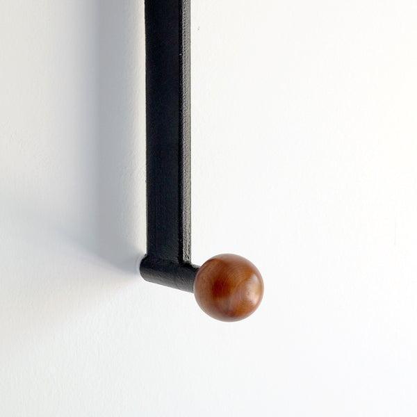 Hook Sconce detail of wood knob on aluminum arm is a wall light with an integrated hook