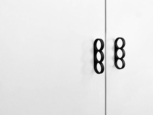 Punch Cabinet Pull black anodized aluminum installed on white cabinet doors