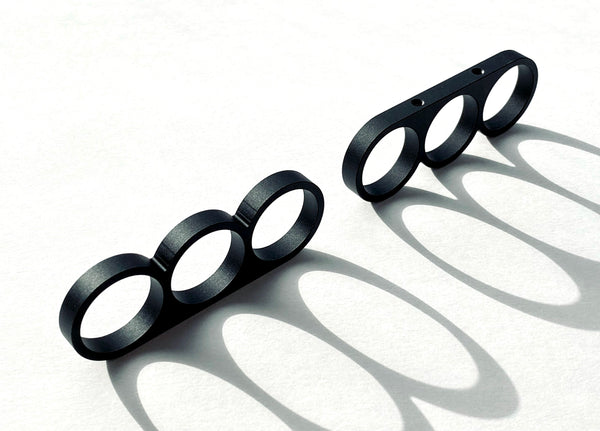 Punch Pulls are cabinet and drawer pulls/knobs for kitchen and bathroom cabinets machined from aluminum with a black anodized finish. The open rings can producing shadow effects on surfaces